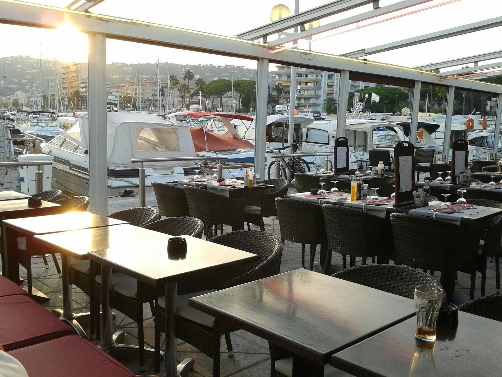 Terrasse de Rio's Banana Café au coucher de soleil, vue sur le port de Golfe-Juan