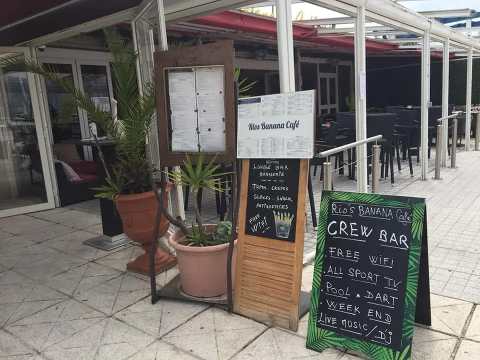 Entrée du Rio's Banana Café avec menu et enseigne en bois