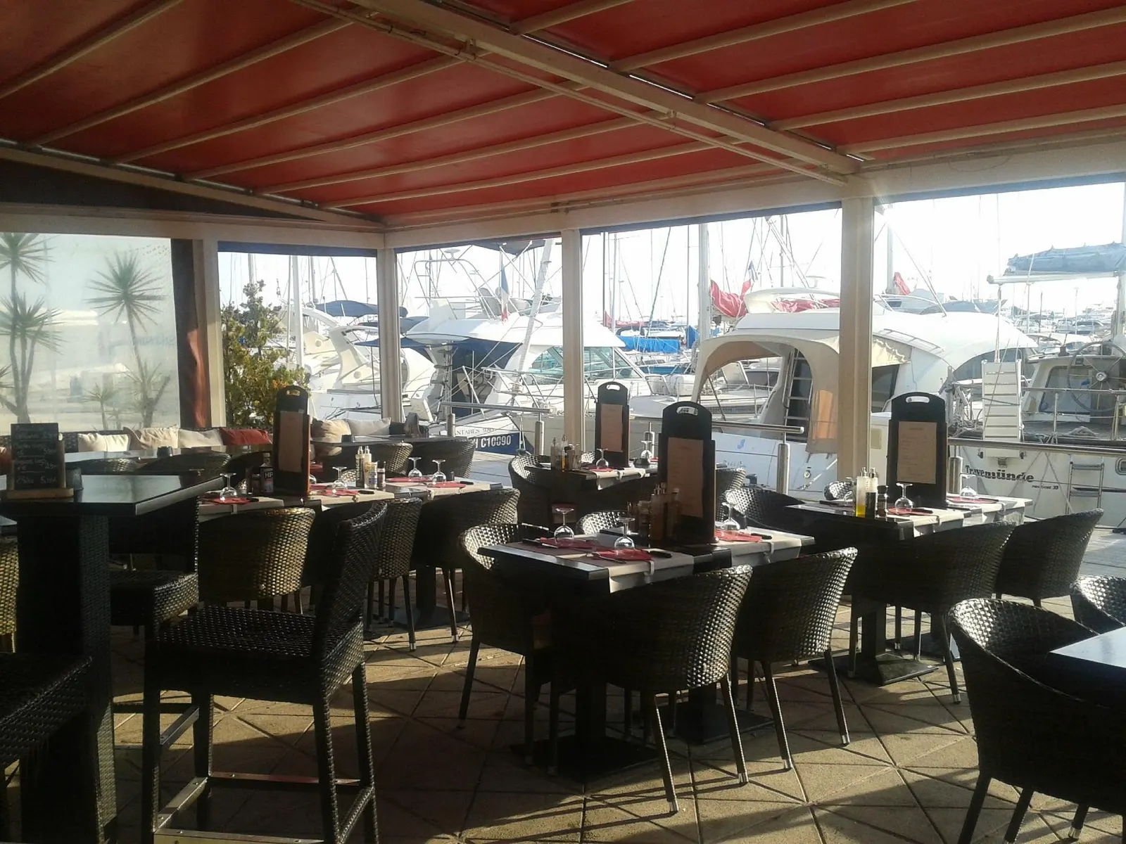 Tables dressées avec vue sur les yachts du port